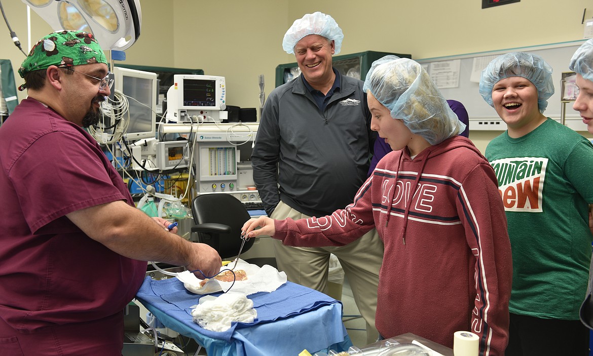 SURGERY TECH Hallie Corbin of Plains helps cauterize a chicken breast as Warren Hill explains how it can be used to stem bleeding from small blood vessels during surgery. Dr. Hanson, Aiden Lyman and Jim Hanson are highly entertained.