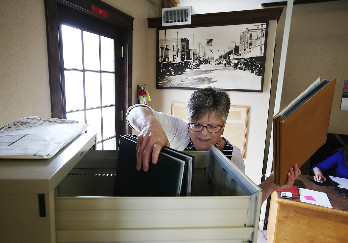 Rathdrum Chamber of Commerce Executive Director Jane Pierce pulls out photo albums from storage to show the press during an interview Thursday. (LOREN BENOIT/Press)