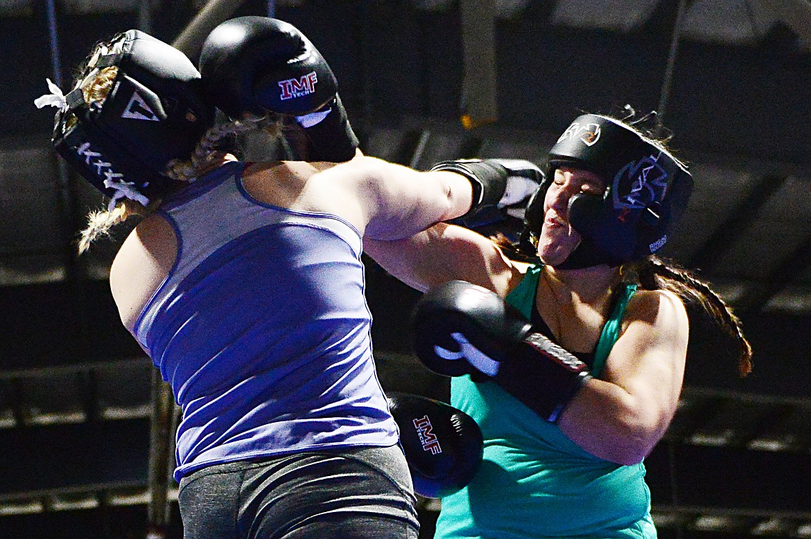Flathead High School's MJ Reed, left, and Glacier High School's Delayny Schulta trade punches during the Crosstown Boxing Smoker at the Flathead County Fairgrounds Trade Center on Thursday. (Casey Kreider/Daily Inter Lake)