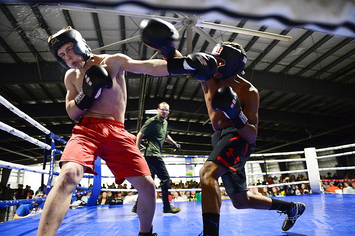 Glacier High School's Colton Todd, left, and Flathead High School's Austin Robinson trade punches during the Crosstown Boxing Smoker at the Flathead County Fairgrounds Trade Center on Thursday. (Casey Kreider/Daily Inter Lake)