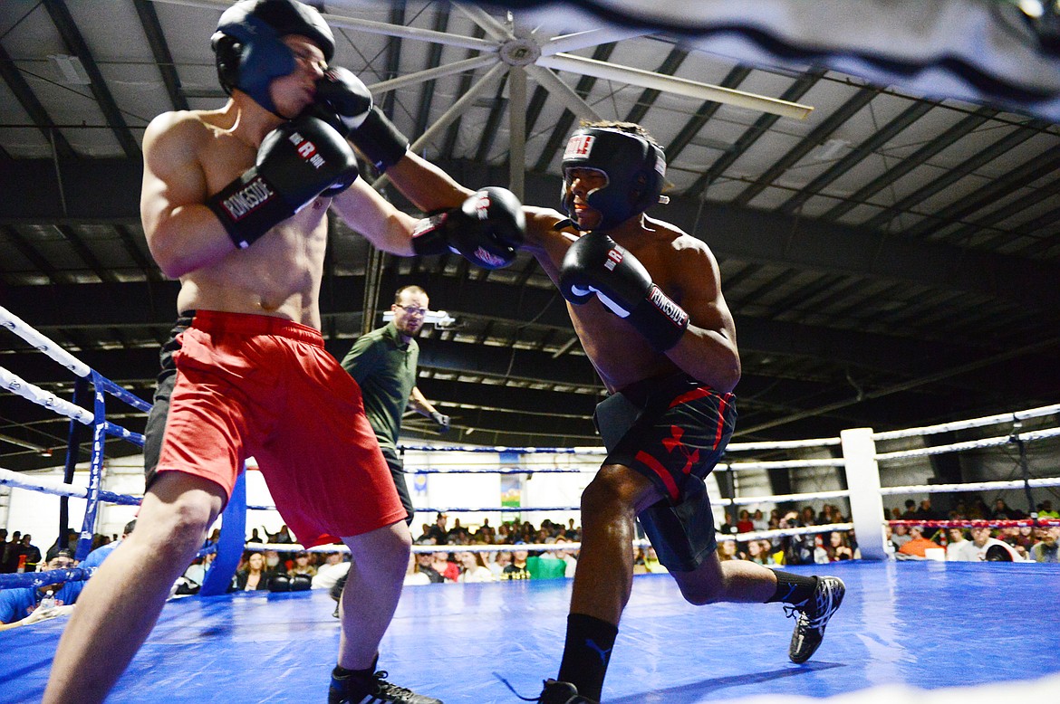 Glacier High School's Colton Todd, left, and Flathead High School's Austin Robinson trade punches during the Crosstown Boxing Smoker at the Flathead County Fairgrounds Trade Center on Thursday. (Casey Kreider/Daily Inter Lake)