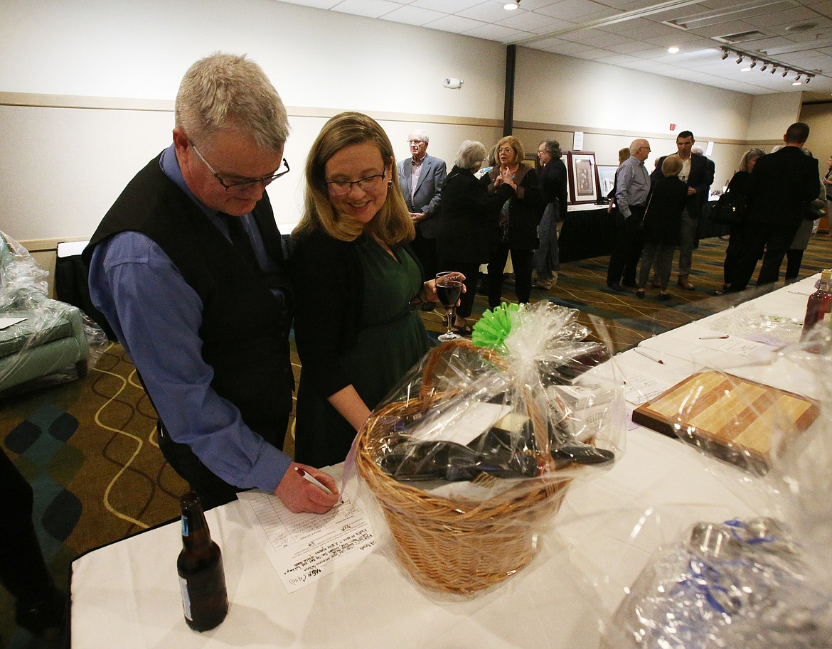 Brian and Jennifer O&#146;Callahan sign their names for a Coeur d&#146;Alene Resort auction item at Friday&#146;s Human Rights Banquet at the Best Western Plus Coeur d&#146;Alene Inn. (LOREN BENOIT/Press)