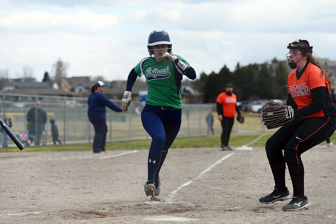 Glacier's Allee Meyer scores on a wild pitch as Flathead pitcher Karissa Comer covers home at Kidsports Complex on Tuesday. (Casey Kreider/Daily Inter Lake)