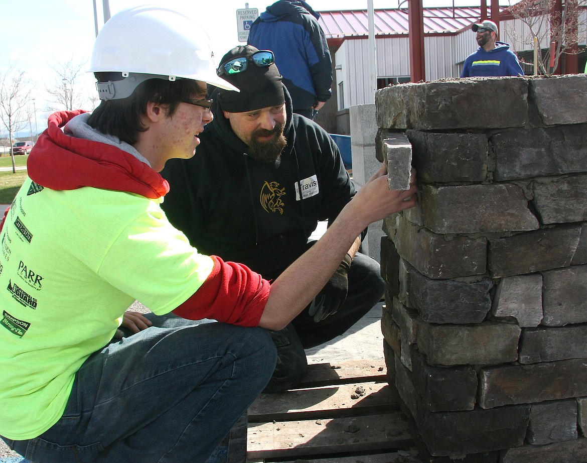 Timberlake High student Ashton Berscheid, left, works alongside Travis Holmes of Gryphon Masonry in Athol during Thursday's Construction Combine at the Kootenai Technical Education Campus in Rathdrum. The event gave students hands-on experience in the construction trades and contractors prospects for employees in a high-demand industry. (BRIAN WALKER/Press)