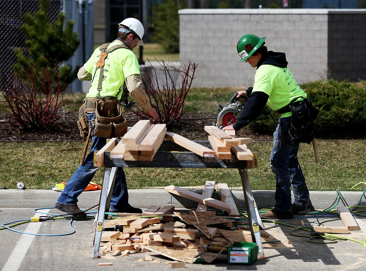 Post Falls High School student Robert Torgerson, left, and Lakeland High School student Jake Durell cut two-by-fours during the Construction Combine event Thursday at Kootenai Technical Education Campus. (LOREN BENOIT/Press)