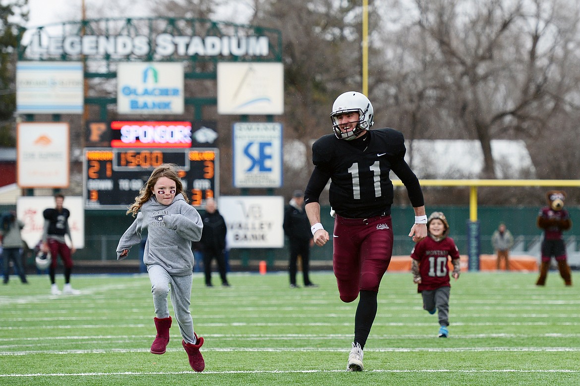 Montana Grizzlies starting quarterback Dalton Sneed (11) races a few youngsters during halftime of the Spring Game at Legends Stadium in Kalispell on Saturday. (Casey Kreider/Daily Inter Lake)