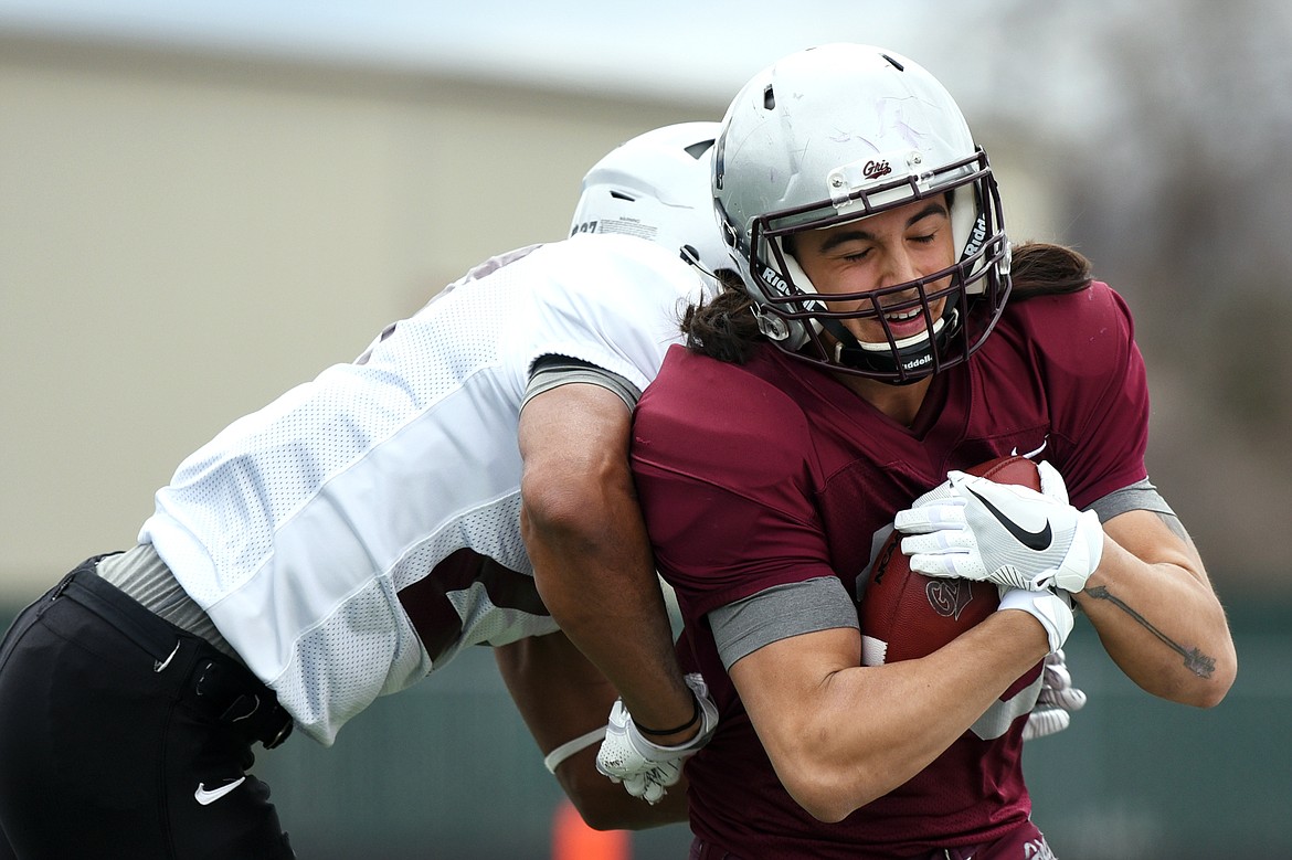 Grizzlies wide receiver Jerry Louie-McGee (16) sheds a tackle by cornerback Kadeem Hemphill (27) on a first quarter reception in the Spring Game at Legends Stadium in Kalispell on Saturday. (Casey Kreider/Daily Inter Lake)