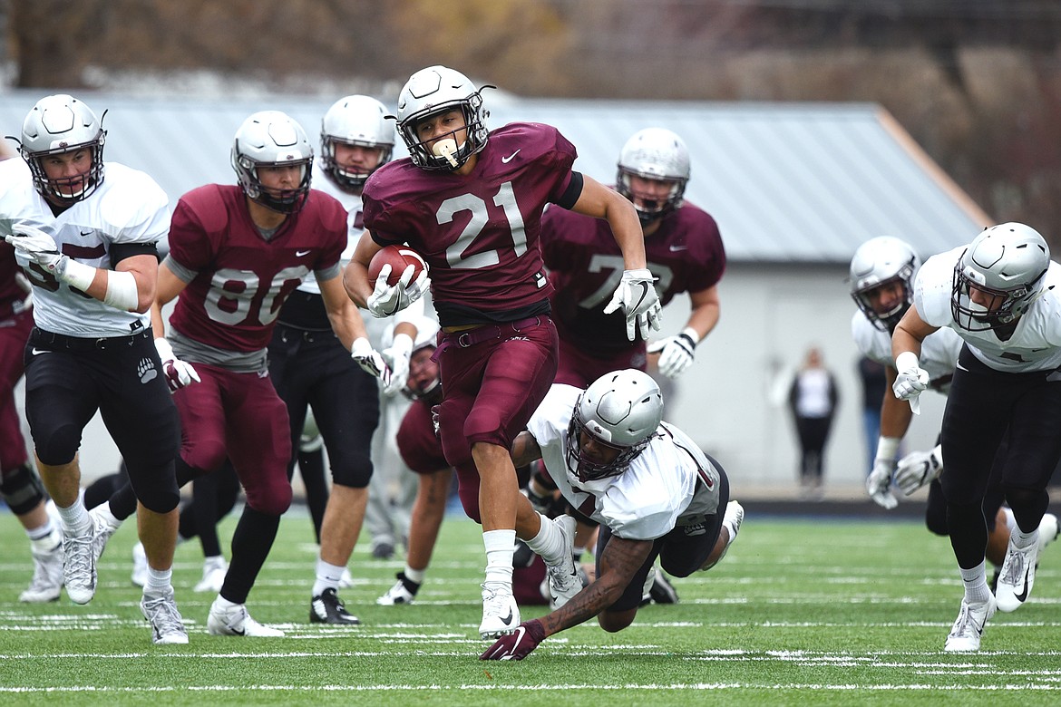 Montana Grizzlies running back Marcus Knight (21) sheds a tackle by cornerback Dareon Nash (7) on a long run in the Spring Game at Legends Stadium in Kalispell on Saturday. (Casey Kreider/Daily Inter Lake)