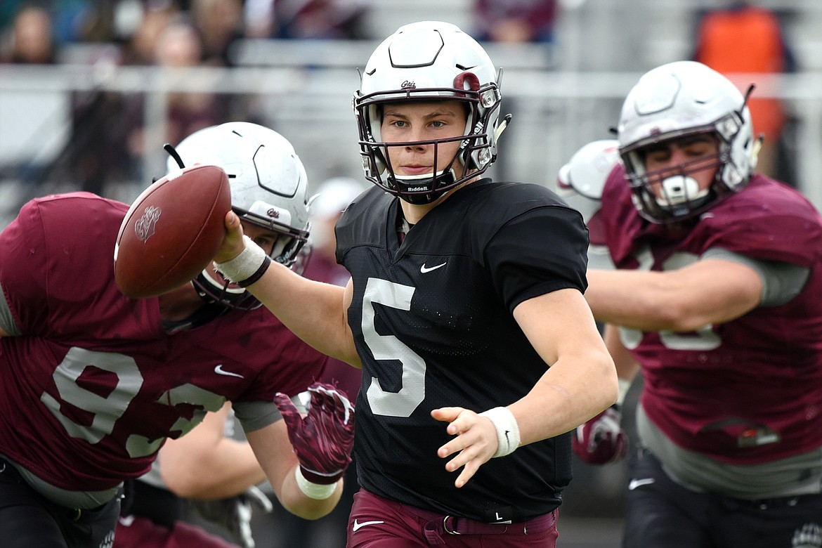 Montana Grizzlies quarterback Garrett Graves (5), from Lincoln County High School, looks to throw as he's flushed from the pocket by defenders Braydon Deming (93) and Alex Gubner (98) during the Spring Game at Legends Stadium in Kalispell on Saturday. (Casey Kreider/Daily Inter Lake)