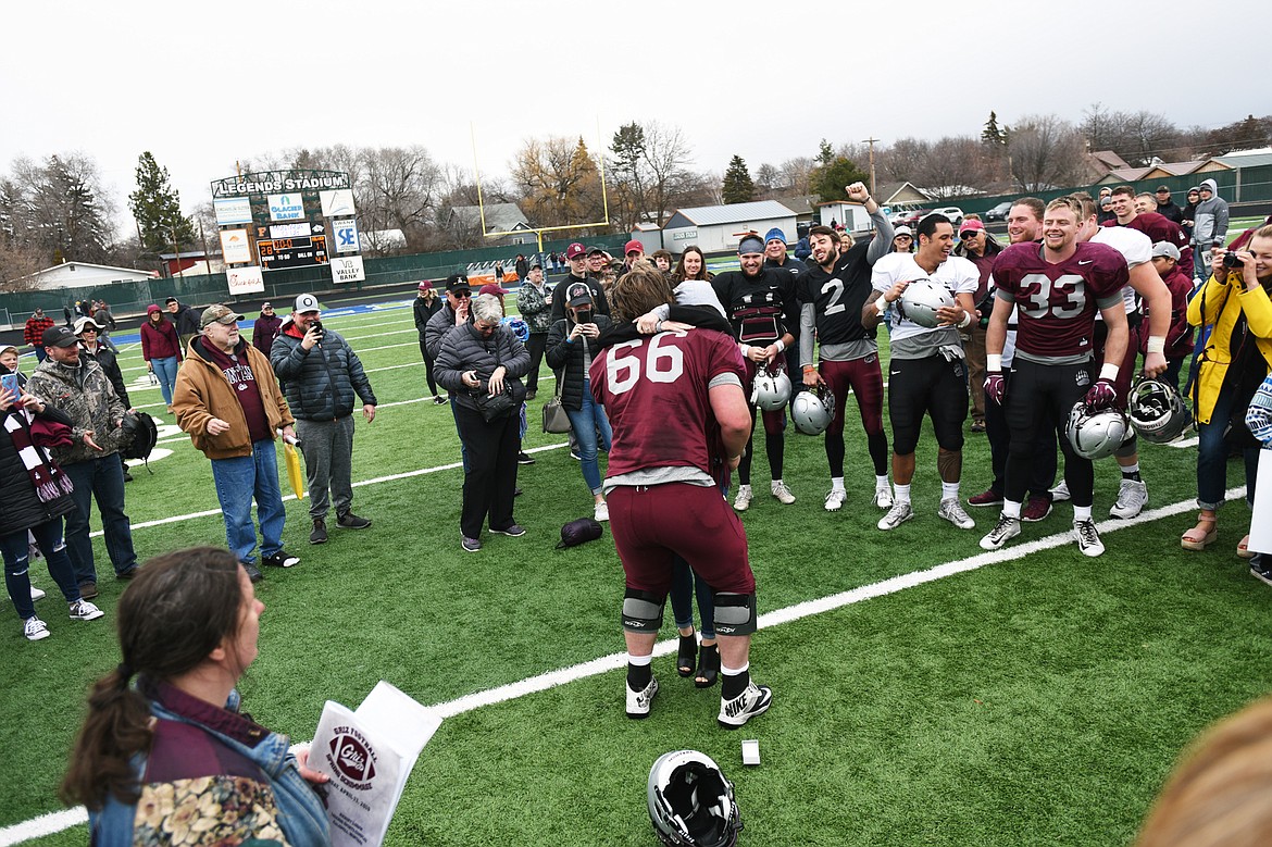 Montana Grizzlies offensive lineman Cy Sirmon (66) hugs his new fiancee Lauren Heiser after he proposed at midfield after the Spring Game at Legends Stadium in Kalispell on Saturday. (Casey Kreider/Daily Inter Lake)