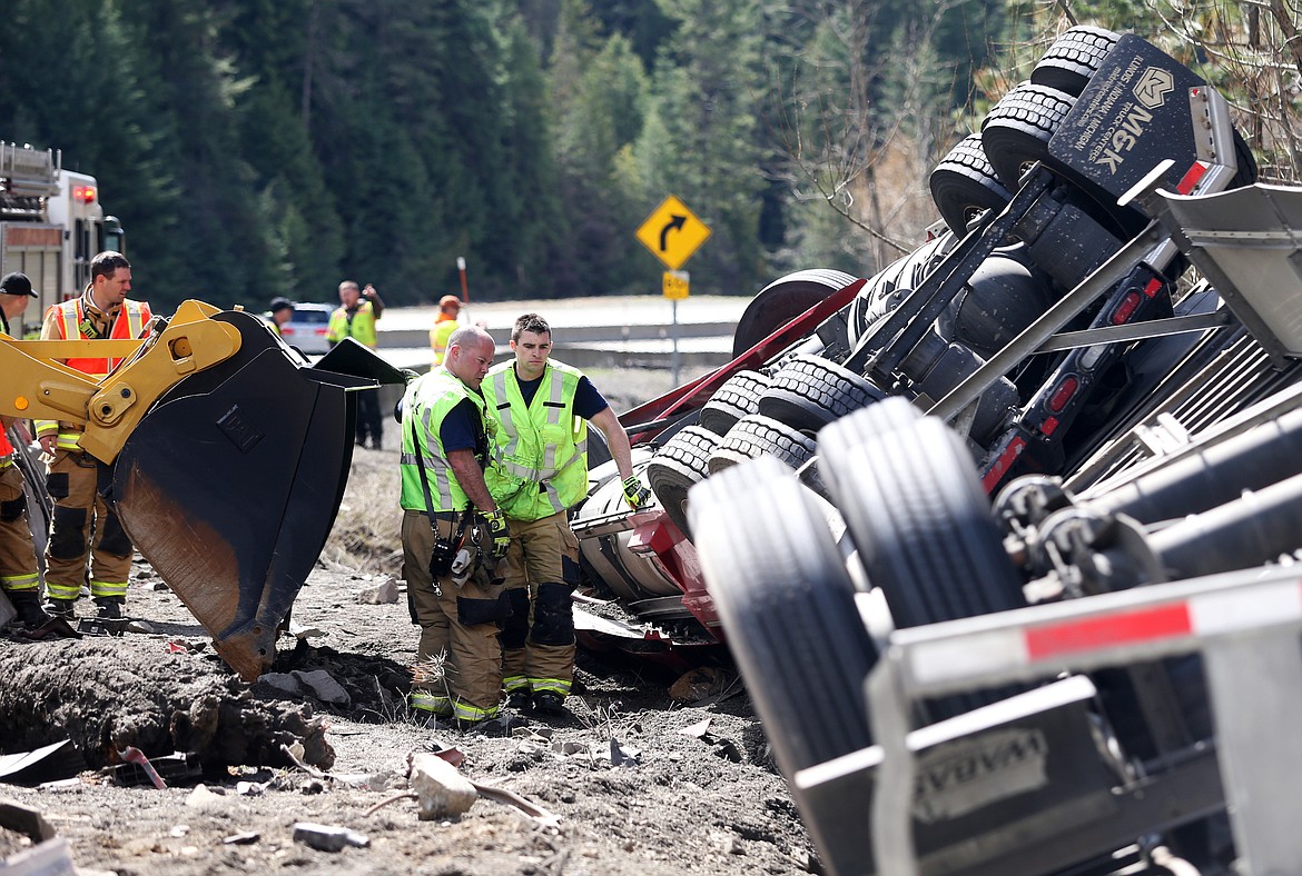 Kootenai County Fire and Rescue Capt. Bryon Smith, left, and   firefighter Kyle Clark work at the scene of a semi truck injury crash on westbound Interstate 90 westbound on Fourth of July Pass on Wednesday. (LOREN BENOIT/Press)
