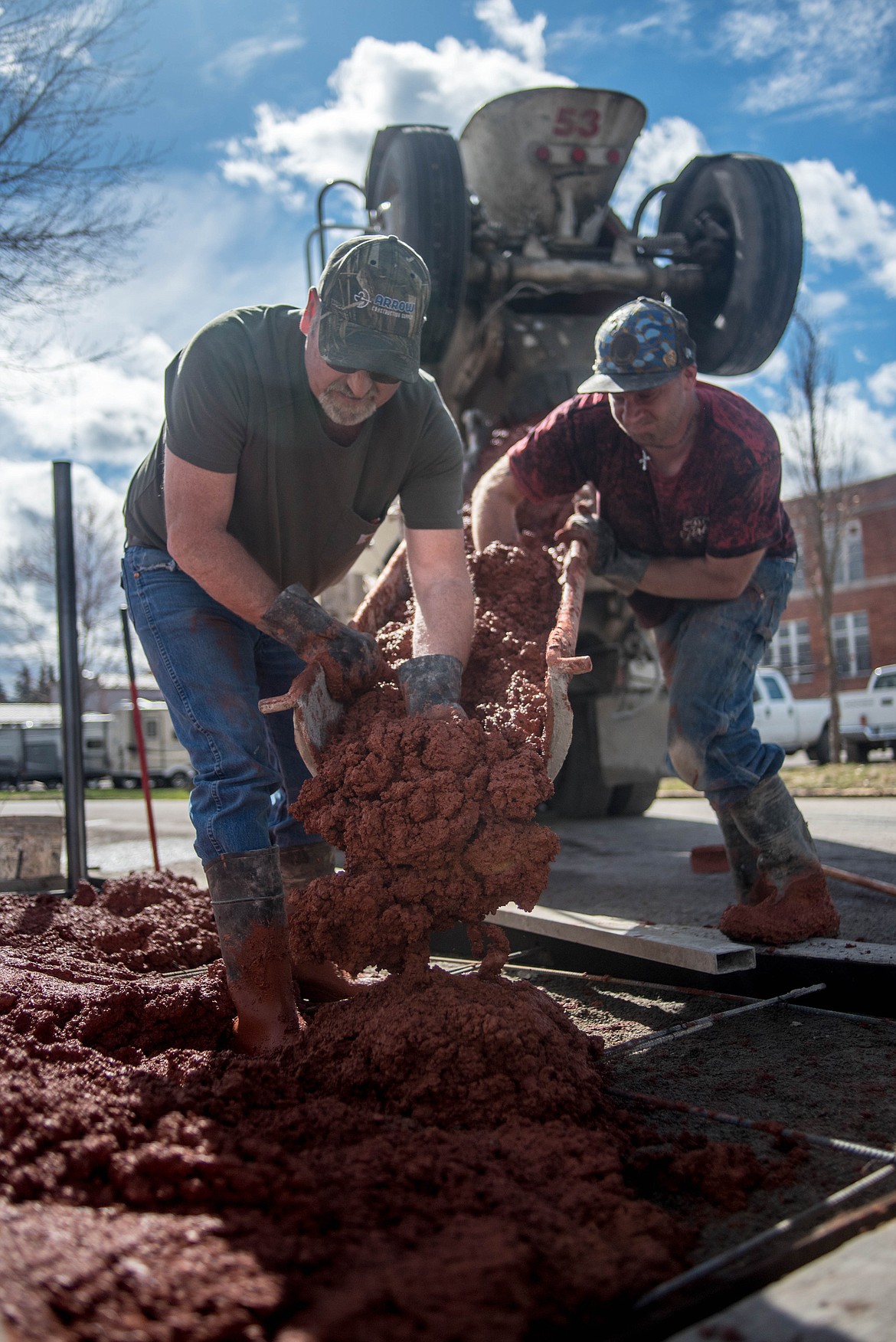 Chuck Riley, left, and Dustin Tracey of Riley Excavating &amp; Concrete lay the cement foundation for Libby&#146;s WWI statue which is being refurbished, Wednesday on Lincoln Boulevard. (Luke Hollister/Ther Western News)