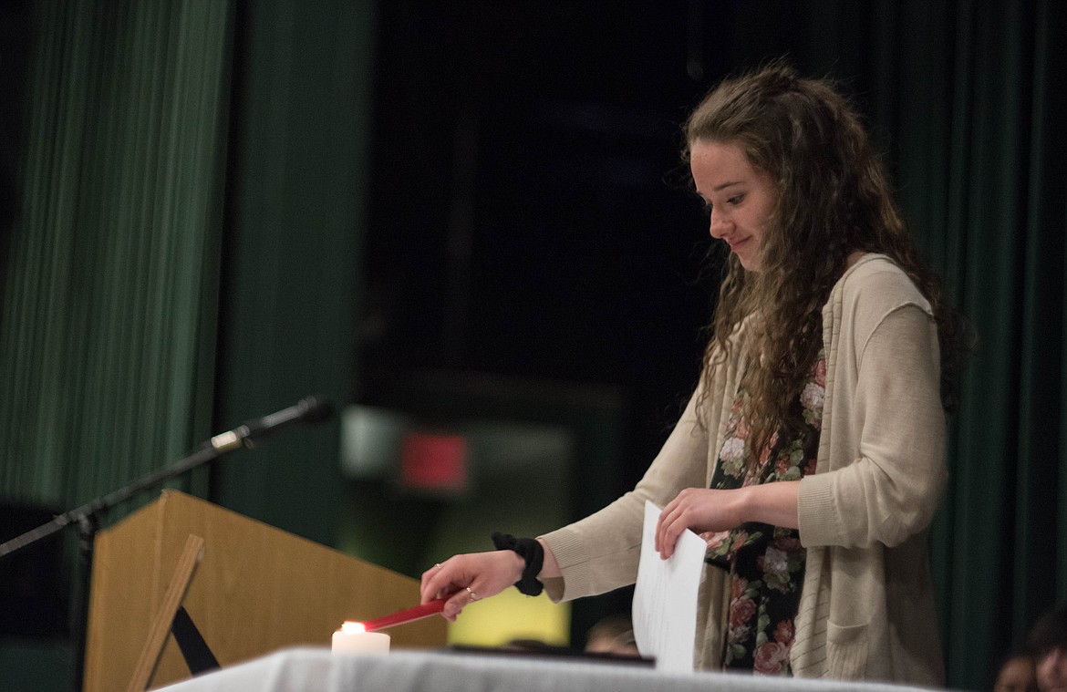 Senior Emma Gruber takes part in the Candle-lighting ceremony during the National Honor Society induction ceremony, April 8 at the Libby Memorial Events Center.