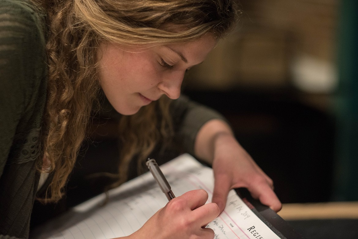 Sophomore Elise Erickson signs an honor registry at the National Honor Society induction ceremony, April 8 at the Libby Memorial Events Center.