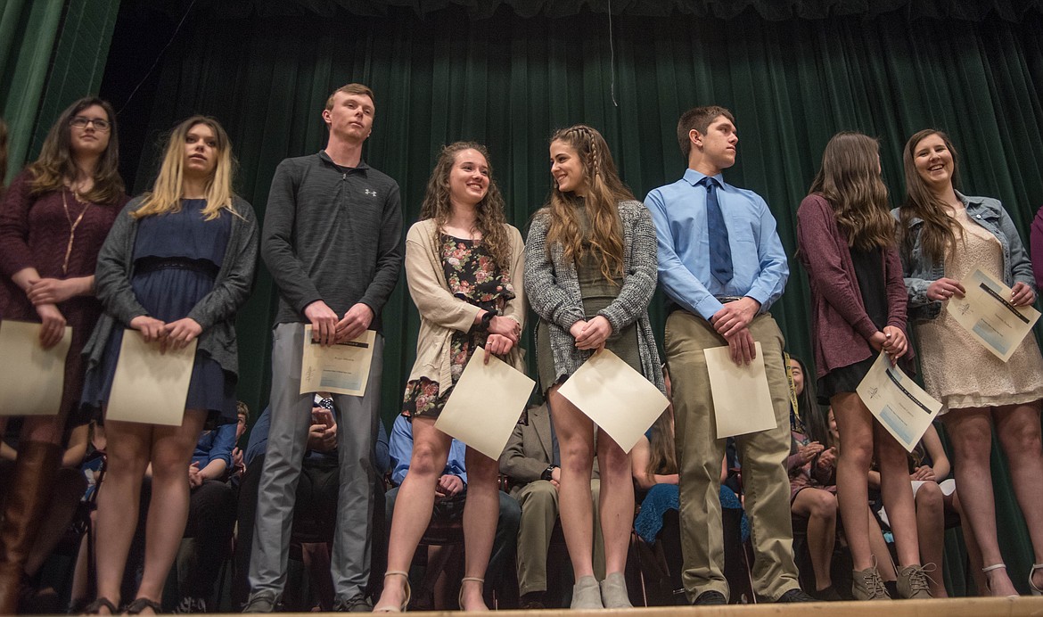 Senior members of the National Honor Society, while holding their certificates of recognition, receive cheers from friends and family at the National Honor Society induction ceremony, April 8 at the Libby Memorial Events Center. The senior members present were (left to right): Sophie Lee, Olivia Kapan, Ryggs Johnston, Emma Gruber, Alli Collins, Ryan Christensen, Hannah Cannon and Sammee Bradeen.