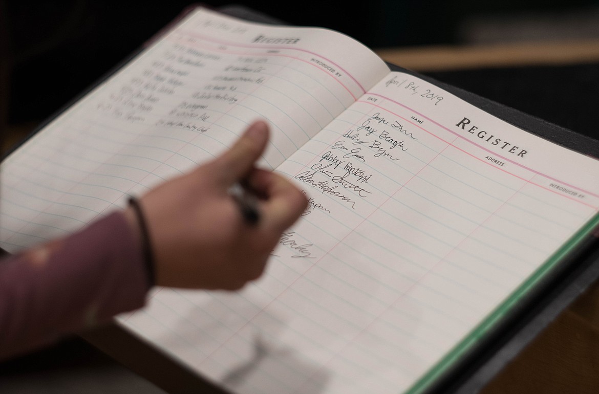 Students sign their names on an honor registry at the National Honor Society induction ceremony, April 8 at the Libby Memorial Events Center.