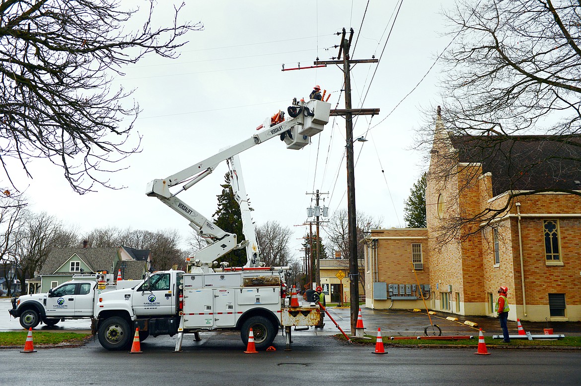 A Flathead Electric Cooperative crew works on a utility pole on Sixth Street East in Kalispell on Wednesday. (Casey Kreider/Daily Inter Lake)