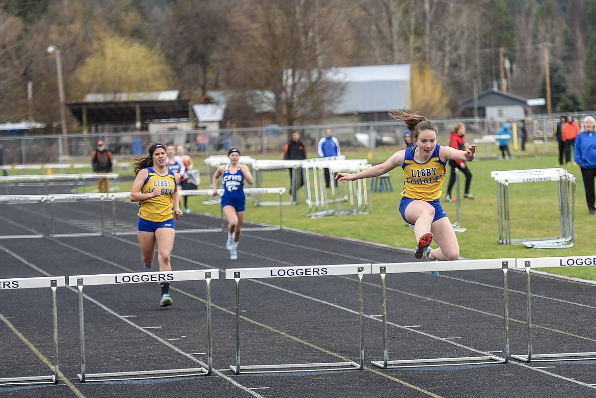 Libby senior Emma Gruber clears the final hurdle in the 300 meter with fellow senior Isabella Hollingsworth close behind, taking first and second, Saturday at the Libby Invitational. (Ben Kibbey/The Western News)