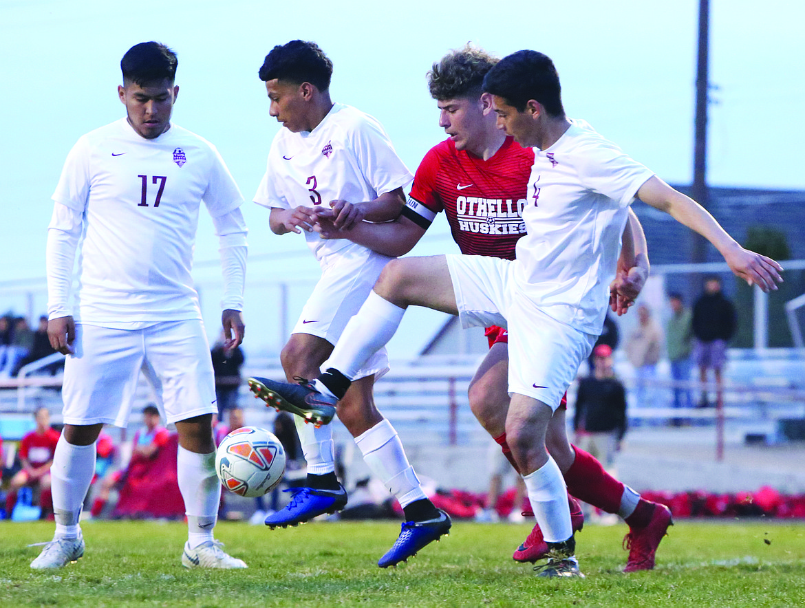 Connor Vanderweyst/The Sun Tribune
Othello midfielder Bernie Garza Jr. (red) can't put a quality shot on goal as he's hounded by the Toppenish defense.