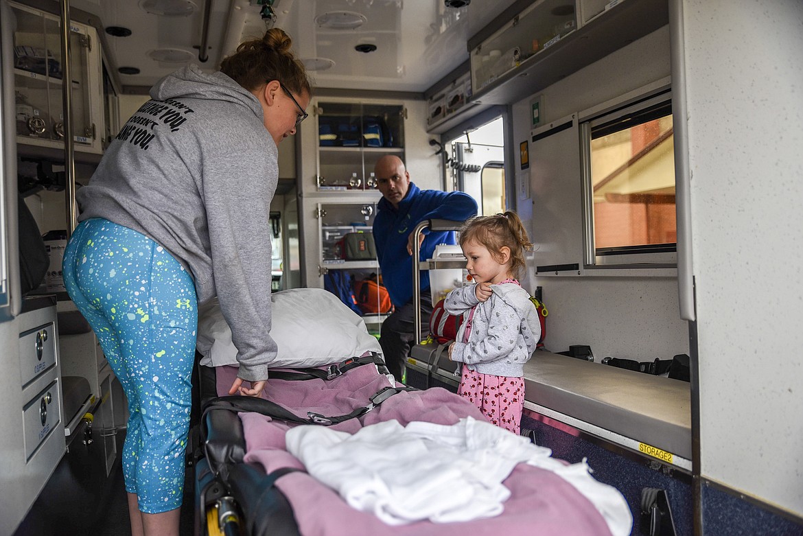 Rachel Smith (left) and Lillian Toland take a look at some of the equipment employed by Libby Volunteer Ambulance as LVA volunteer Keith McBride looks on at the Cabinet Peaks Medical Center Annual Health Fair at the Libby Memorial Events Center on Saturday. (Ben Kibbey/The Western News)