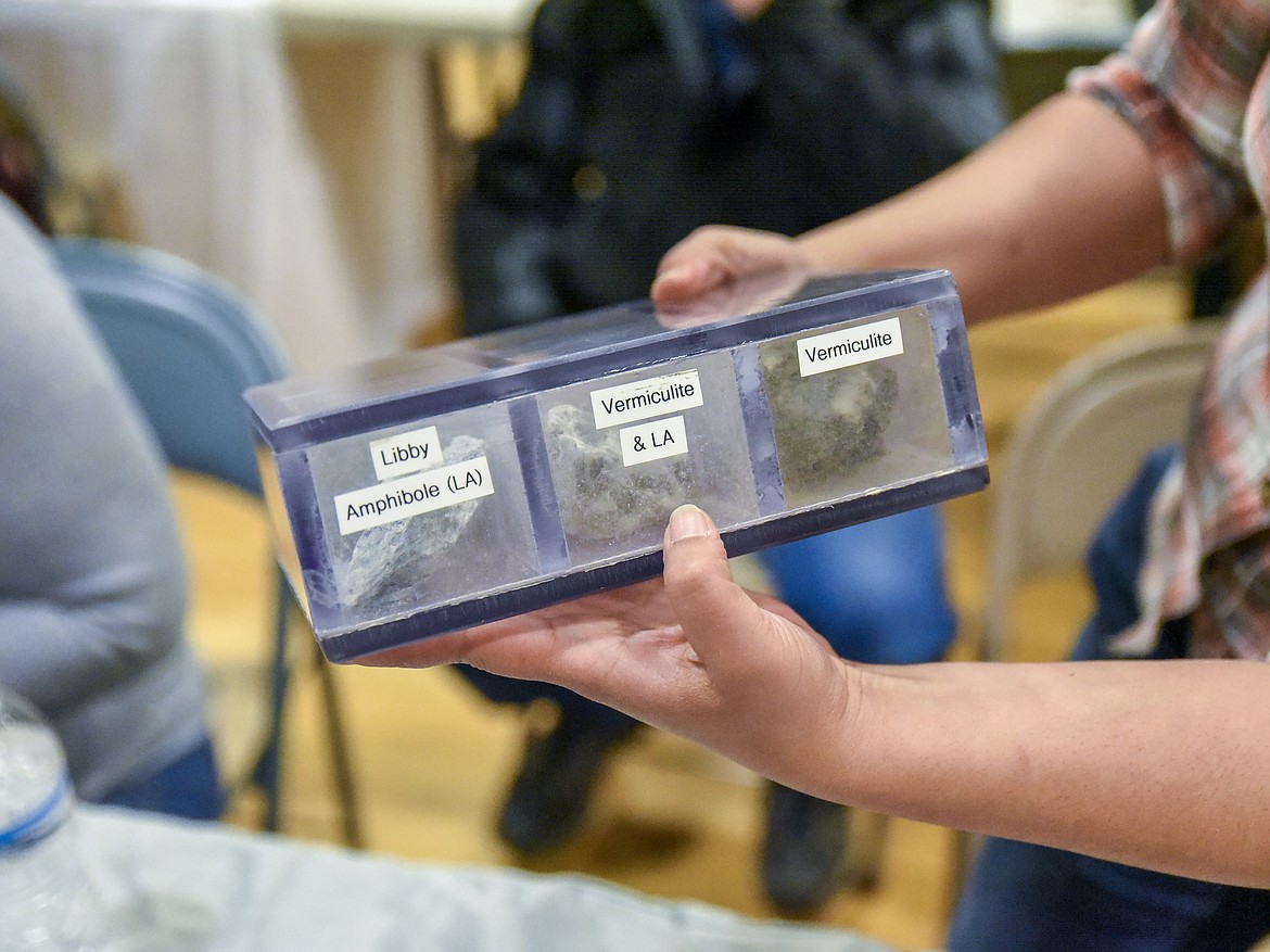 Asbestos Resource Program Director Virginia Kocieda holds up a container with vermiculite and Libby amphibole asbestos samples during the Cabinet Peaks Medical Center Annual Health Fair at the Libby Memorial Events Center on Saturday. (Ben Kibbey/The Western News)