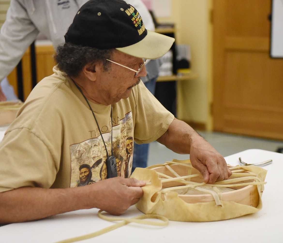 TOM CAMEL of Ronan uses rawhide lacing to attach a tanned hide to a cedar hoop to frame a drum. This skill takes manual dexterity, which Camel exhbited during the activity.