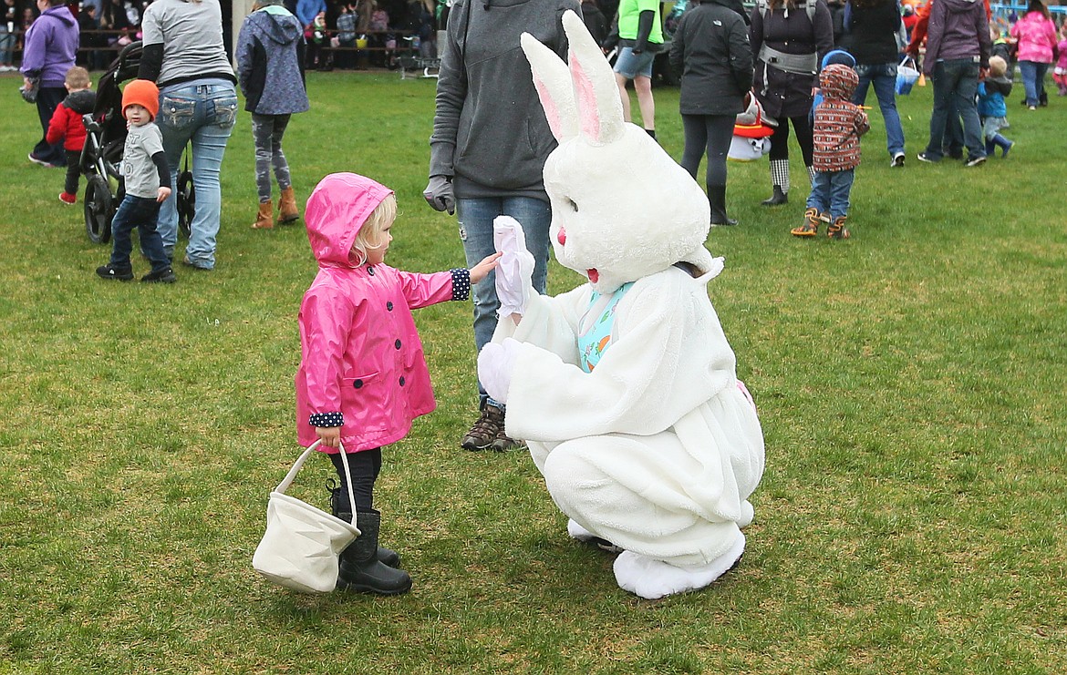 Ezrah Kemp, 2, of Coeur d&#146;Alene, gets a high five from the Easter Bunny after the Real Life Ministries Easter Egg Hunt in McEuen Park on Saturday morning. Ezrah also won a first prize egg and got to go home with a sweet new playset, complete with a playhouse and a slide. (DEVIN WEEKS/Press)