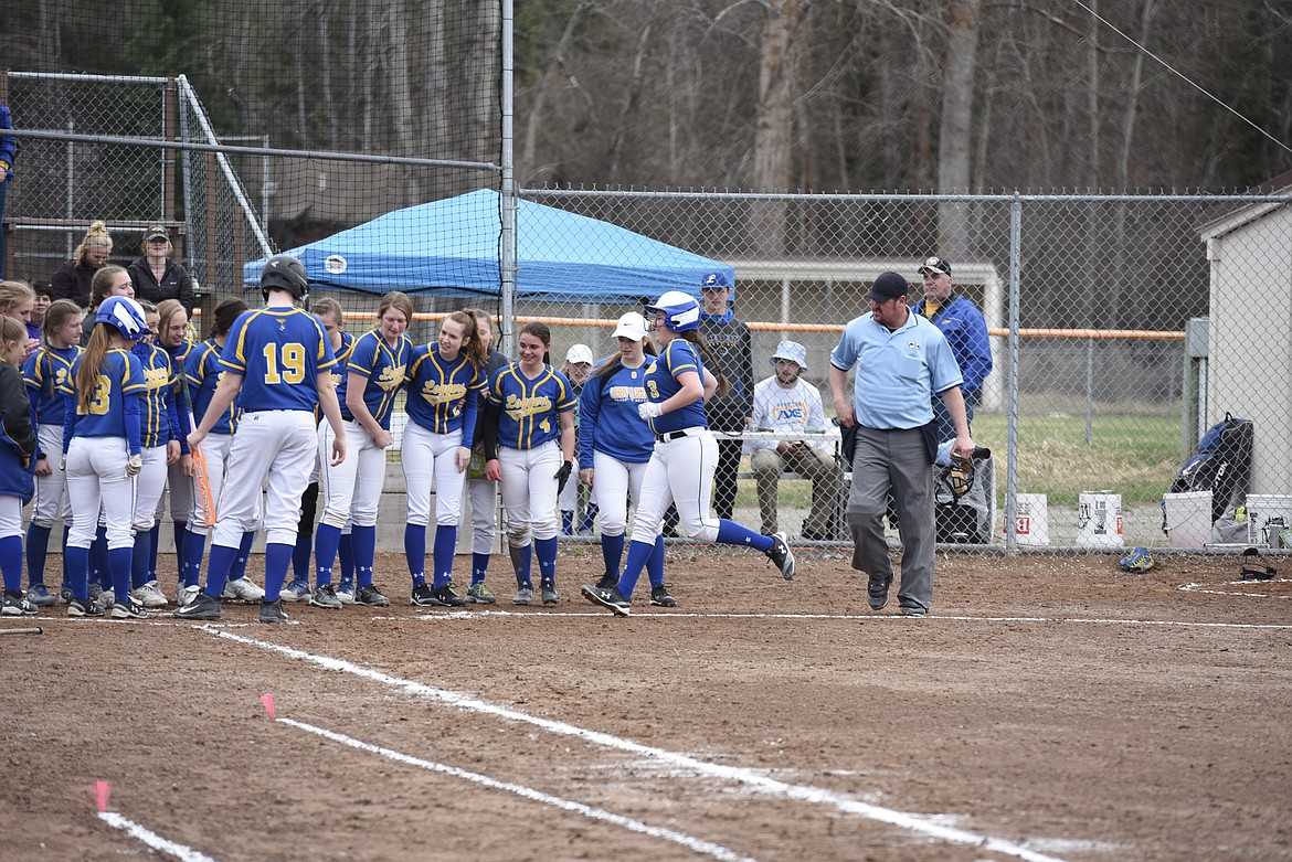 Libby senior Samme Bradeen is greeted by her teammates after her first homer, bottom of the third, Saturday at home against Ronan. (Ben Kibbey/The Western News)