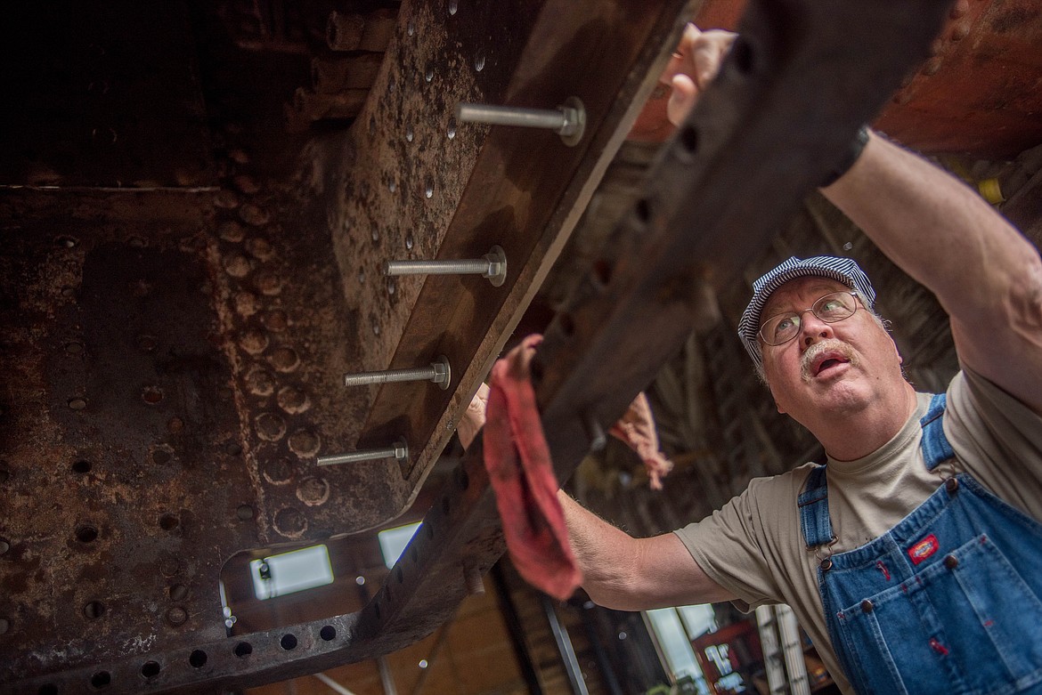 Wayen Croeger, a Heritage Museum volunteer fixing up the Shay locomotive, shows the bottom side of the old train, April 18 at the museum in Libby. (Luke Hollister/The Western News)