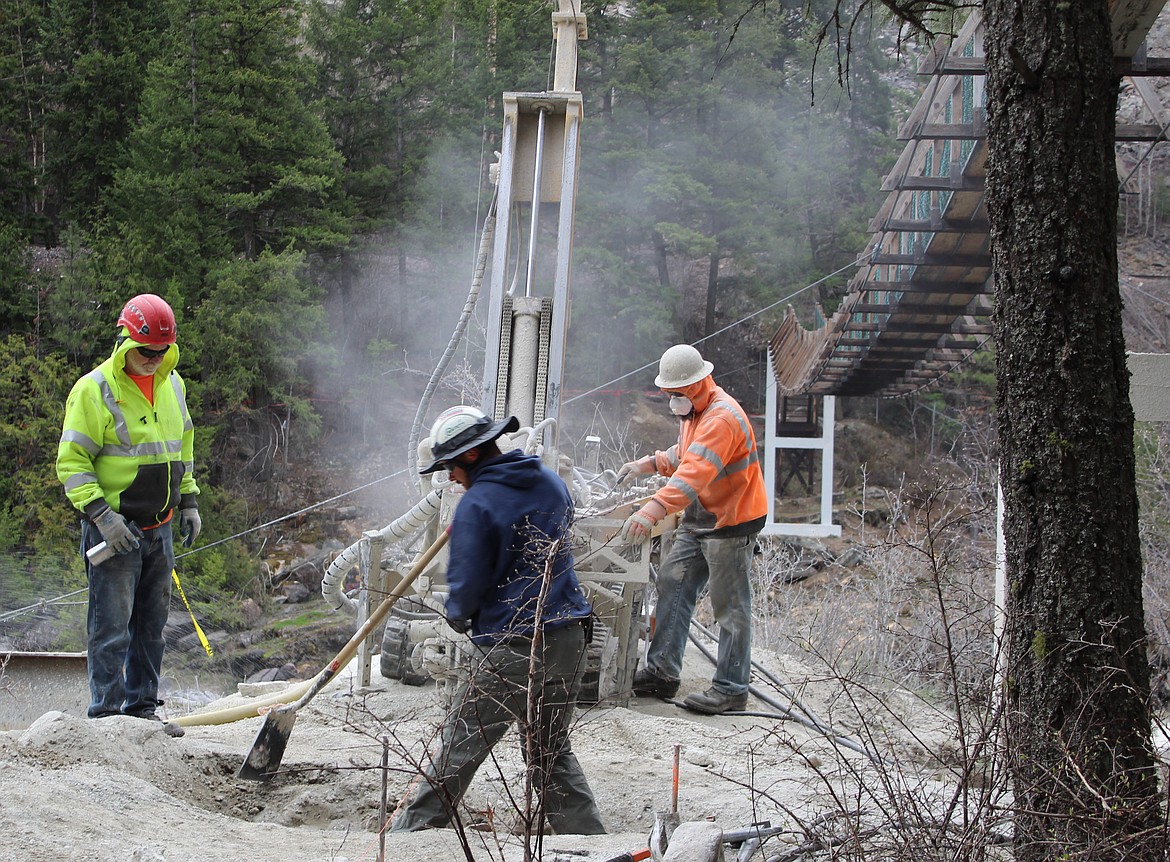 A crew from Budinger &amp; Associates of Spokane Valley drills holes in rock Thursday to install elements that will help support the structure for a new swinging bridge across the Kootenai River near Libby. The workers are, left to right, Terry Feiler, Jack Pappas and Joseph Boullt. (Duncan Adams photos/Daily Inter Lake)