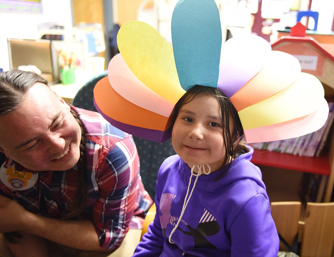 JUNIPER FIRST STRIKE, a first-grader at Cherry Valley Elementary, waits with her dad Rod to have her face painted during Night of the Arts activities.