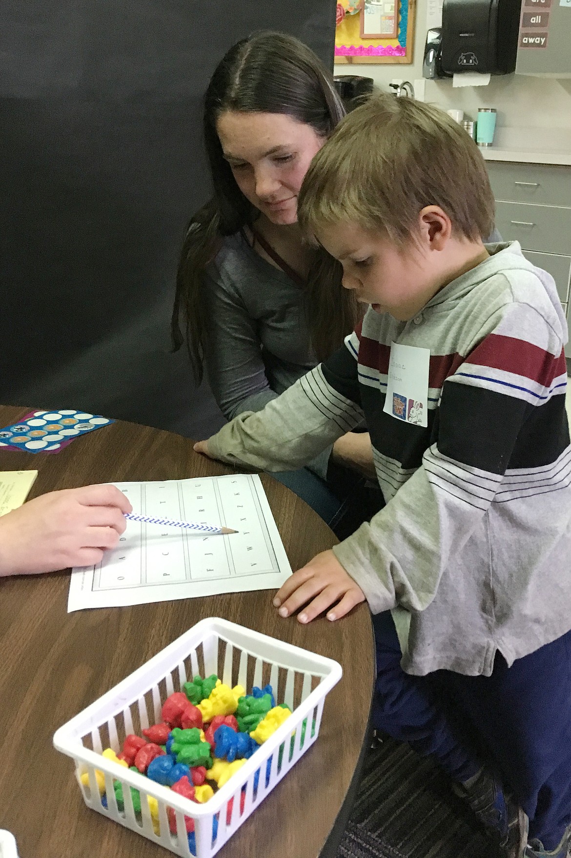 SOME KINDERGARTNERS approached with circumspection, others with confidence or curiosity. Isaak Erickson blew out a sigh of relief after passing his letters test. Mom Nikki cheered him on. (Carolyn Hidy/Clark Fork Valley Press)