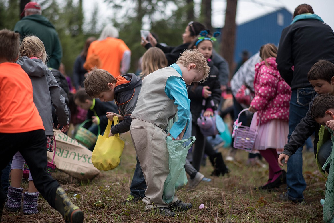 Joey Richter, 6, loads his bag with a new find during the Easter Eggstravaganza Egg Hunt, Saturday at the Libby Christian Church. (Luke Hollister/The Western News)