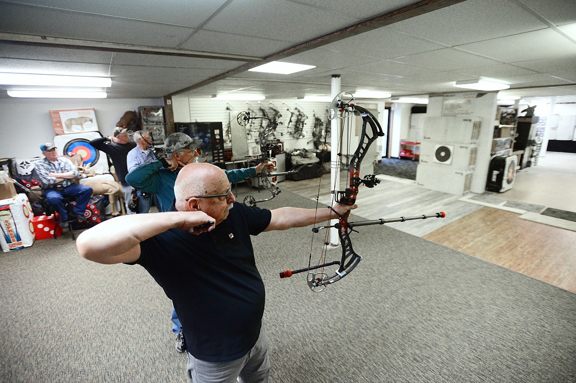 Kalispell resident Tony Dupont, foreground, and other archers practice at the range inside Flaming Arrow Archery in Evergreen on Tuesday, April 23. (Casey Kreider/Daily Inter Lake)