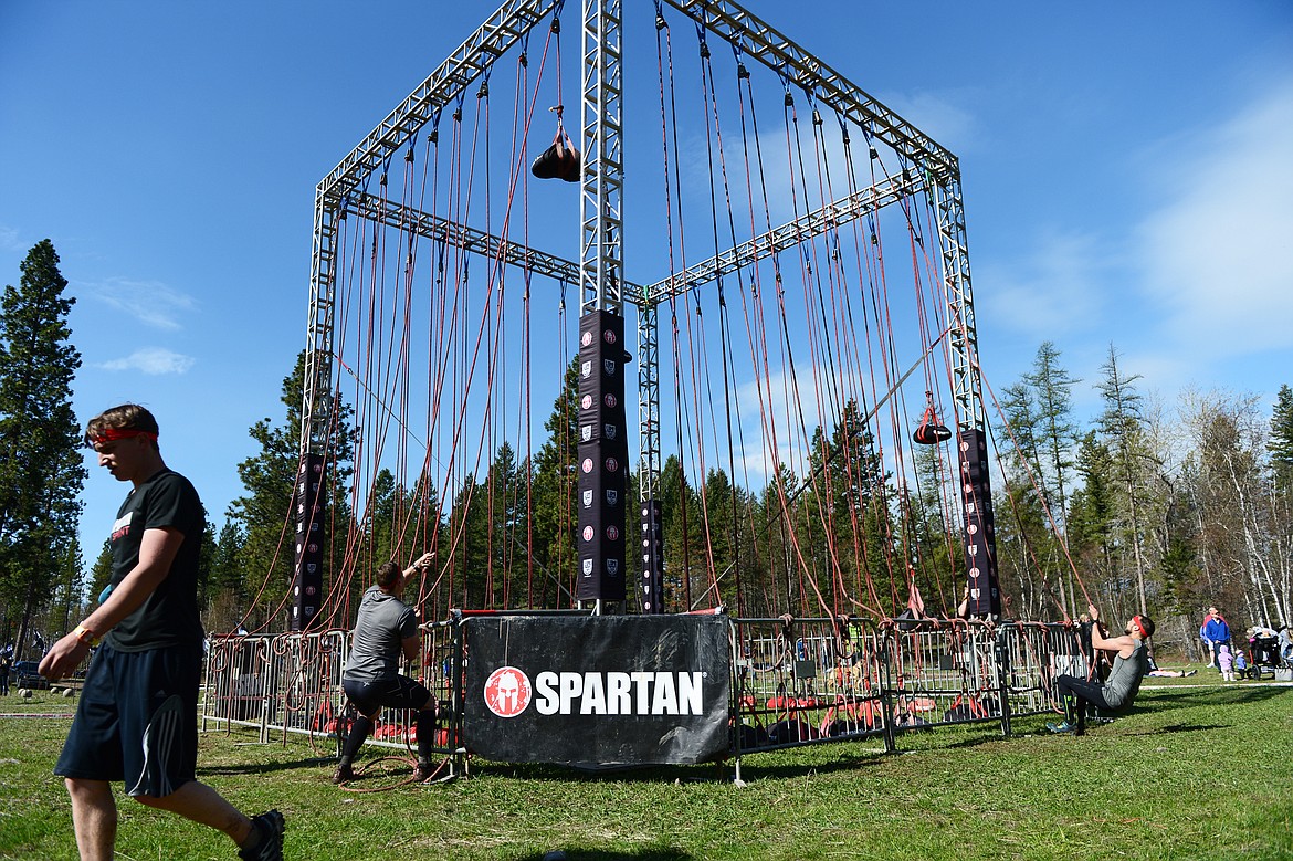 Competitors perform the Hercules Hoist during the 13-mile Spartan Beast race at Flathead Lake Lodge in Bigfork on Saturday. (Casey Kreider/Daily Inter Lake)