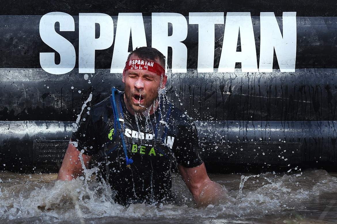 A competitor emerges from the Dunk Wall during the 13-mile Spartan Beast race at Flathead Lake Lodge in Bigfork on Saturday. (Casey Kreider/Daily Inter Lake)