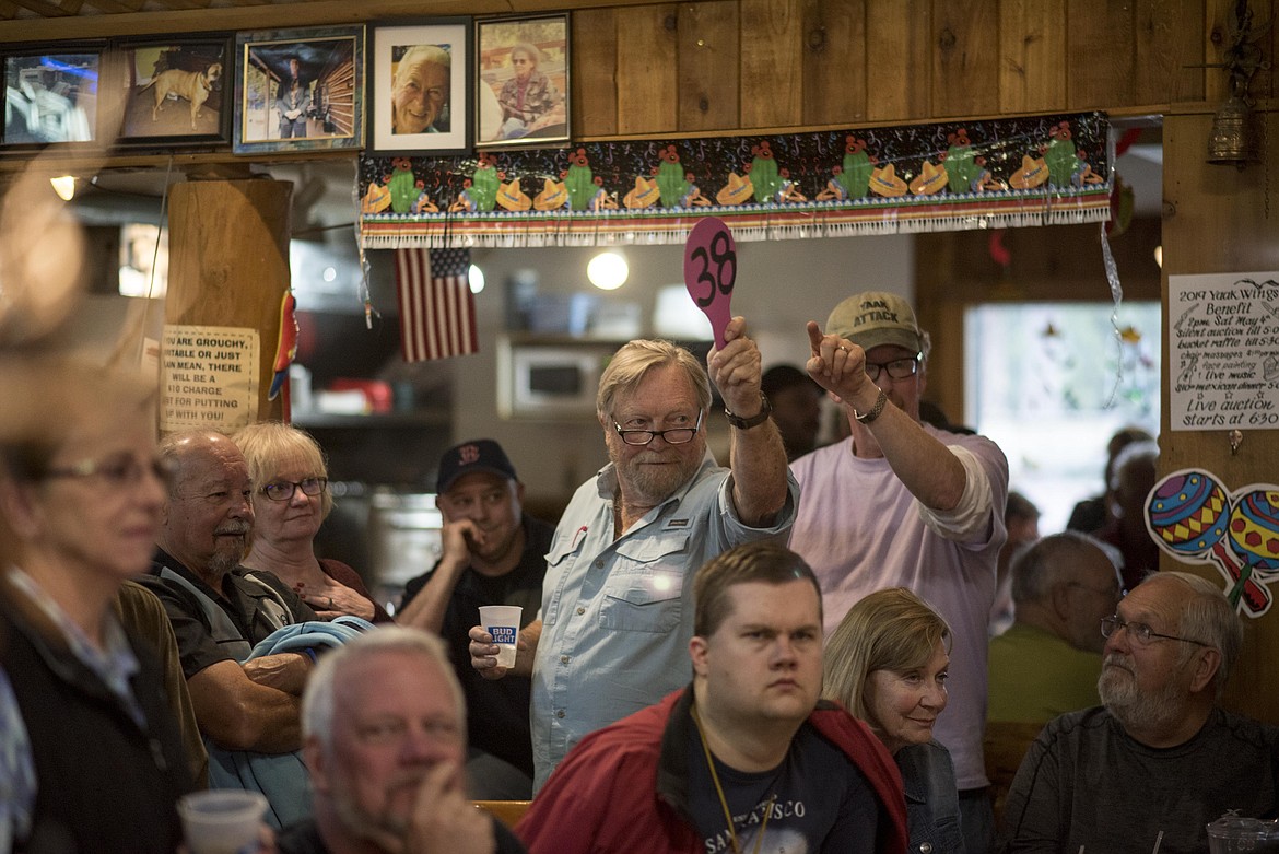 Paul Johnson raises a bid during a Wings fundraiser, Saturday at the Yaak River Tavern and Mercantile. (Luke Hollister/The Western News)