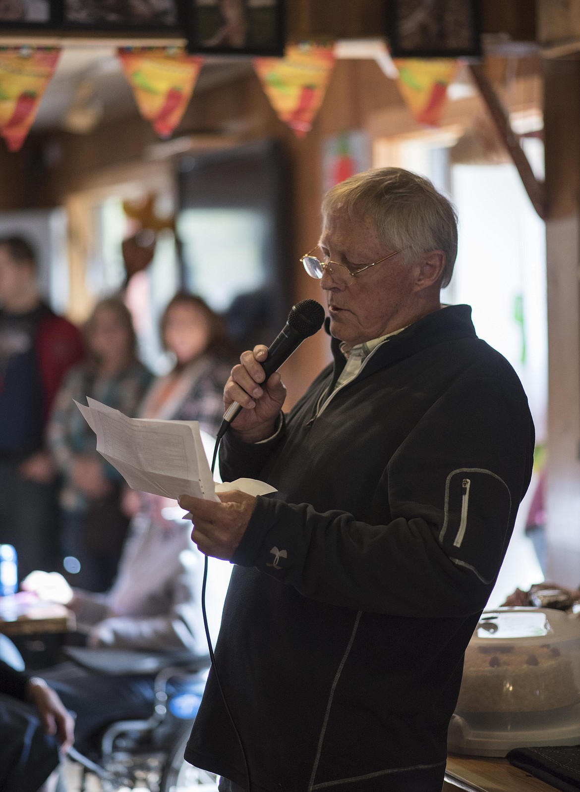 Jim Mayo reads off the names of donators to Wings before the live action begins, Saturday at the Yaak River Tavern &amp; Mercantile. (Luke Hollister/The Western News)