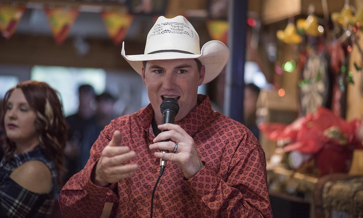 Kelly Morford, an auctioneer for the Wings fundraiser, rattles off prices as people bid, Saturday at the Yaak River Tavern &amp; Mercantile. (Luke Hollister/The Western News)