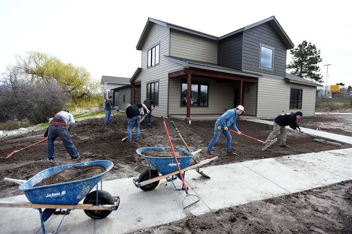 Construction students prep the ground for landscaping and eventual installation of an irrigation system and sod outside a student-built home on Corporate Drive in Kalispell on Wednesday. The students are part of the Kalispell Student Built Homes program where they learn how to build a house beginning with flagging property lines.