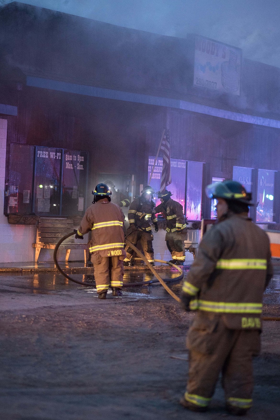 Firefighters exit the inside of Moody&#146;s Dirty Laundry &amp; Self-Service Dog Wash, Friday night in Libby. Assistant Chief/Fire Marshall Steve Lauer said parts of the fire were &#147;a little tougher getting to&quot; than anticipated. (Luke Hollister/The Western News)
