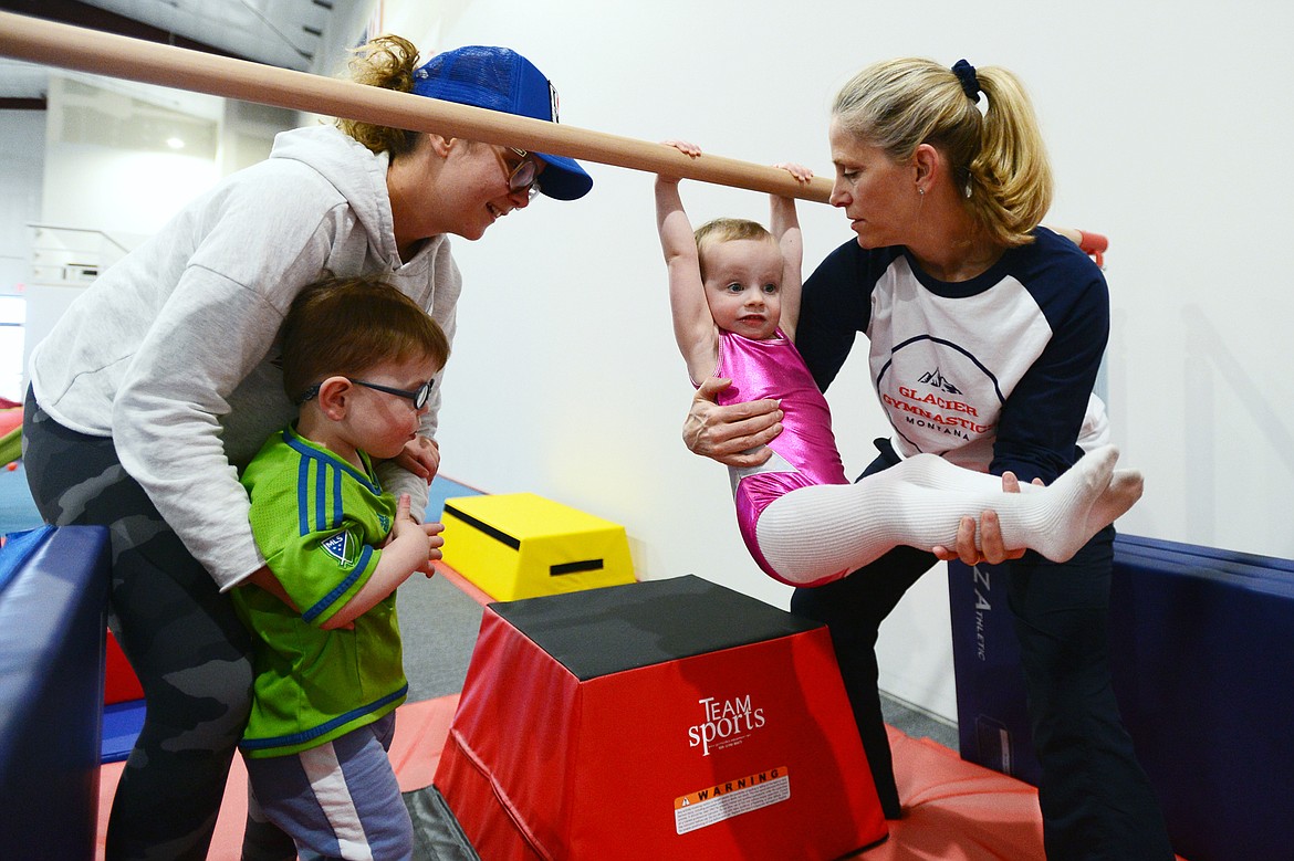 Distler introduces Parker Laabs, 2, to the parallel bar during the parent and tot class.