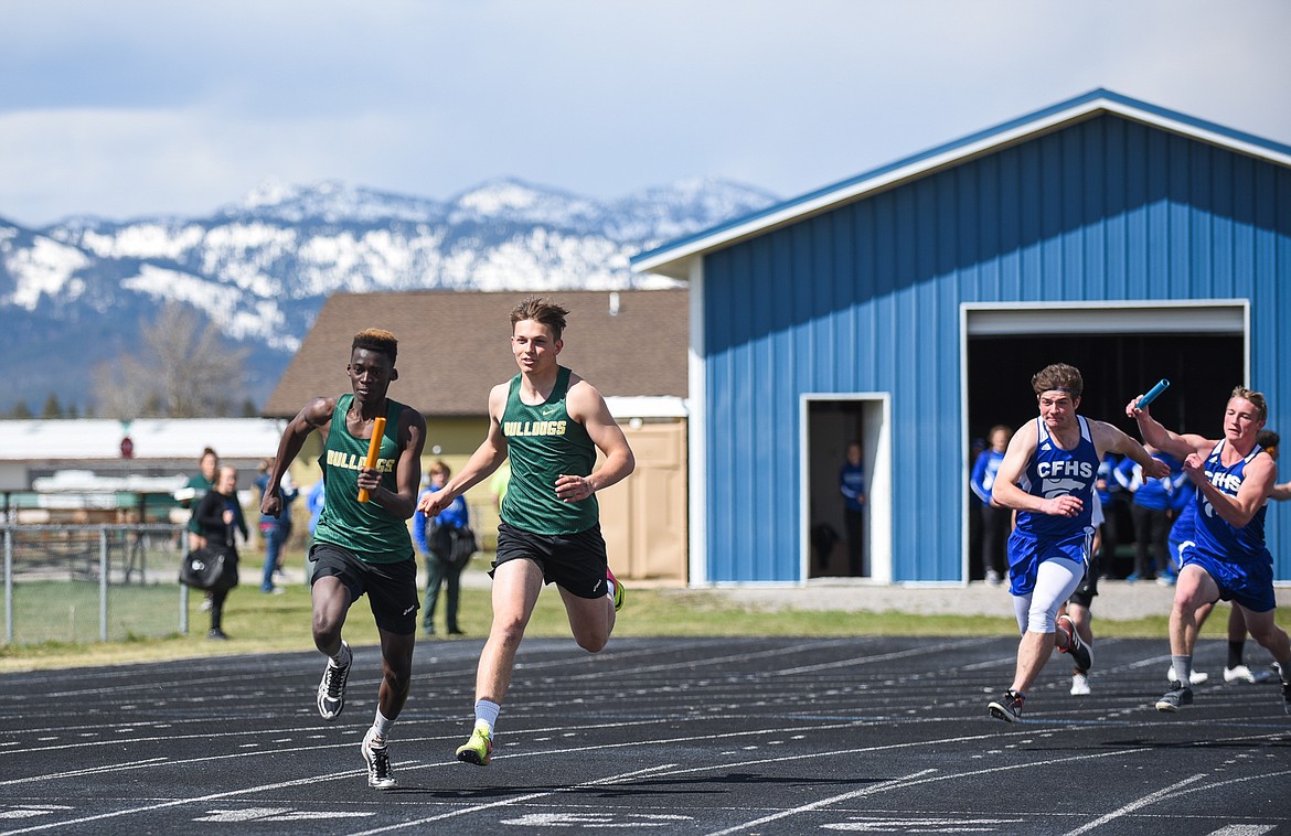 Jack Schwaiger passes the baton to Marvin Kimera in the 400 relay at Columbia Falls last Tuesday. (Daniel McKay/Whitefish Pilot)