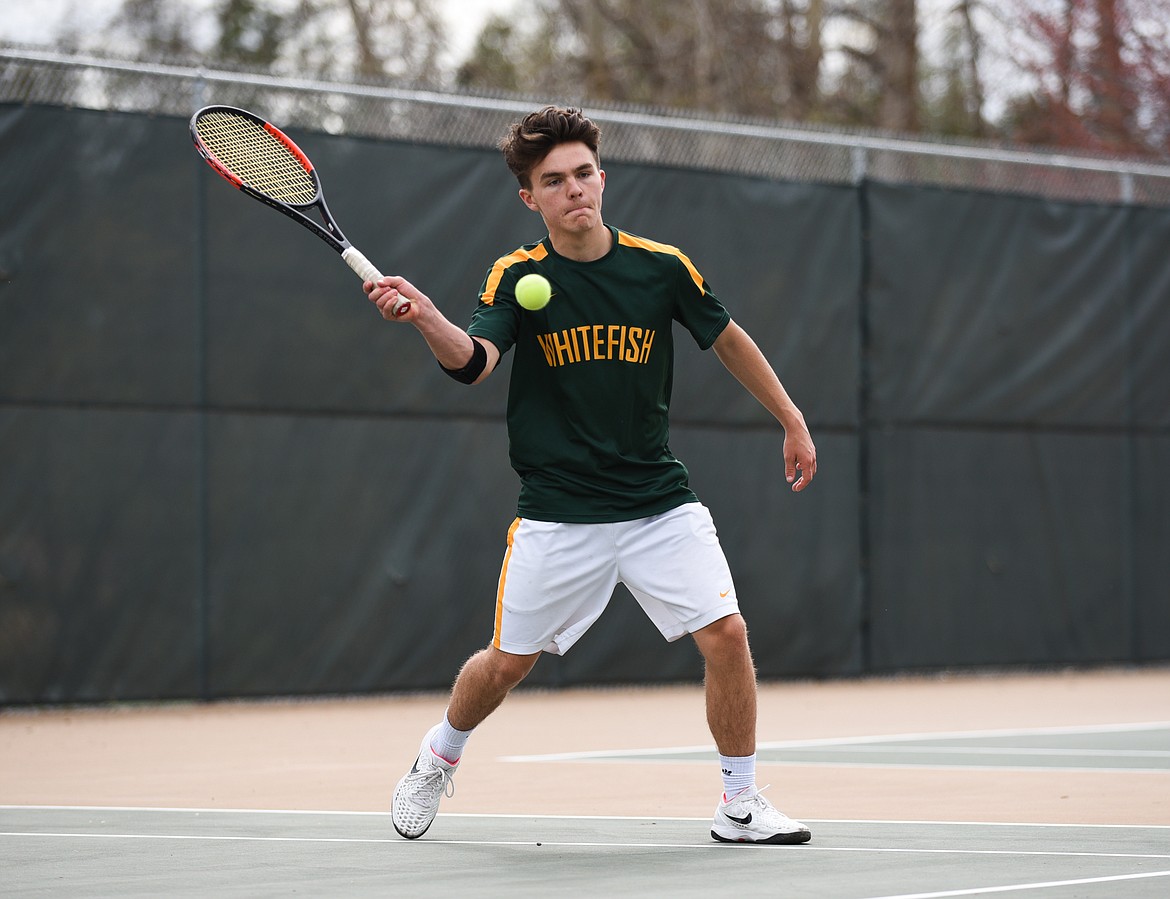 Brendan Buls returns a serve against Libby on Saturday. (Daniel McKay/Whitefish Pilot)