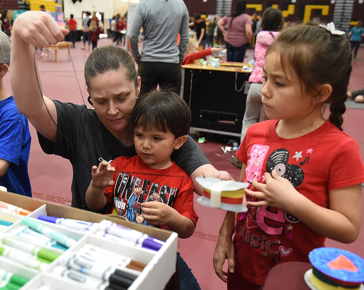 GRANDMOTHER YA YA Robbins helps Isaac and Sharae Mahseelah make and drum and drumsticks dudring the Science and Tech Festival last Saturday.