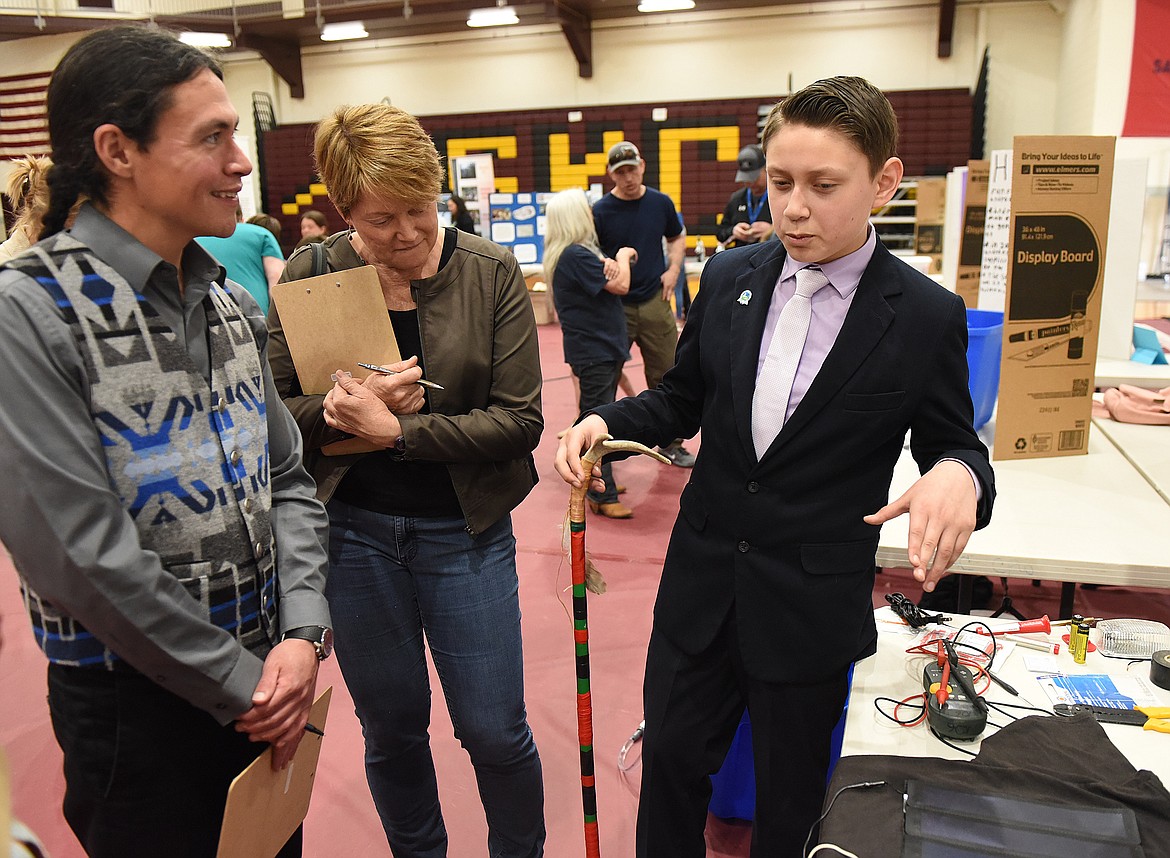 AIDEN SORRELL was perhaps the best-dressed exhibitor during the Science and Tech Festival at Salish Kootenai College. Judges listen to his presentation.