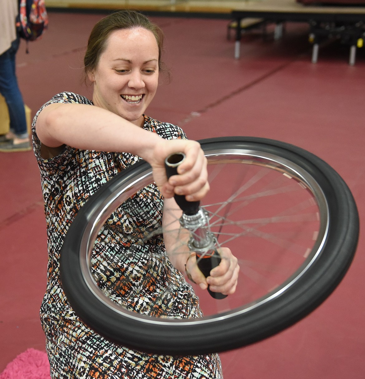 AFTER HER daughter Macy gave it a try, Emily Jordan leans the physics involved in a spinning bicycle wheel and tire. Turn it just right and your chair spins in circles.