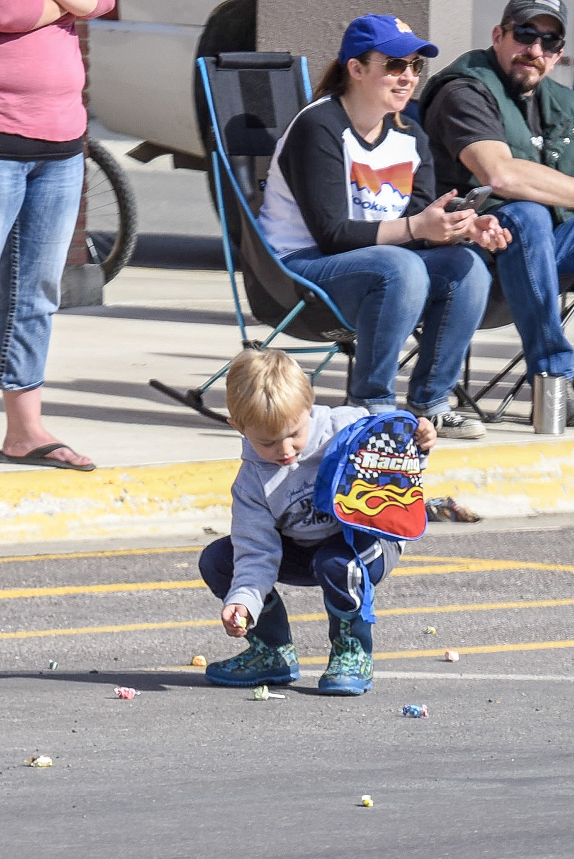 Colt Gassett fills up his pack with candy, during the Opening Day Parade in Libby, Saturday. (Ben Kibbey/The Western News)
