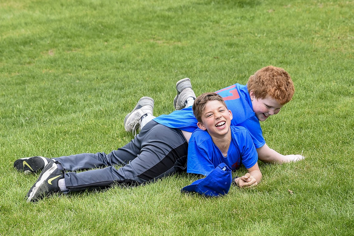 Trevor Guinard holds down Carson Orr during a little rough-housing as the ball players waited for activities to begin at Roosevelt Park following the Opening Day Parade in Troy, Saturday. (Ben Kibbey/The Western News)