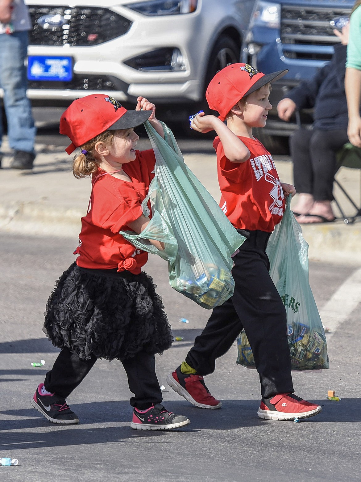 Riley Kavert and Bowen Thompson throw candy during the Opening Day Parade in Libby, Saturday. (Ben Kibbey/The Western News)